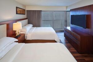 a hotel room with two beds and a flat screen tv at Hilton Grand Vacations Club Hokulani Waikiki Honolulu in Honolulu +31 photos