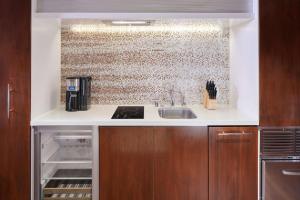 a kitchen with a sink and a brick wall at Hilton Grand Vacations Club Hokulani Waikiki Honolulu in Honolulu