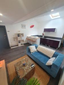 ein Wohnzimmer mit einem blauen Sofa und einer Küche in der Unterkunft Seeside Oasis in Clermont-Ferrand