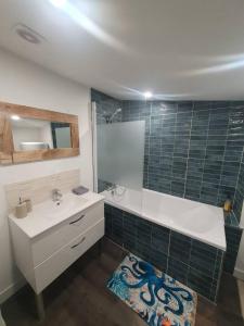 ein Badezimmer mit einem weißen Waschbecken und einem Spiegel in der Unterkunft Seeside Oasis in Clermont-Ferrand