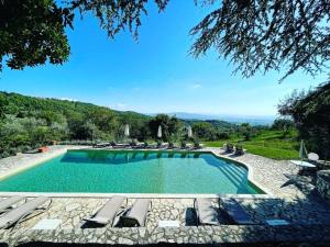 a swimming pool with lounge chairs and a view of the mountains at Villa Godenano - Country Chianti Villa in Castellina in Chianti