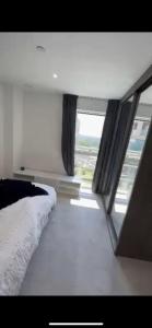 Schlafzimmer mit einem Bett und einem Fenster in der Unterkunft Spacious one bedroom luxury apartment in Kidbrooke Greenwich in London