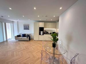 a living room with a glass table and a couch at Spacious one bedroom luxury apartment in Kidbrooke Greenwich in London