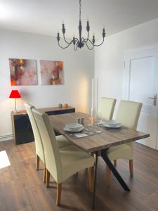 een eetkamer met een houten tafel en stoelen bij City Apartment, Ferienwohnung 3 ZKDB, Balkon, Dachgeschoss, nähe Düsseldorf in Krefeld