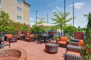 a patio with chairs and tables and an umbrella at Hilton Garden Inn Hattiesburg in Hattiesburg