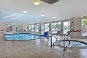 una grande piscina con vasca idromassaggio in un edificio di Hilton Garden Inn Hattiesburg a Hattiesburg