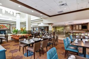 una sala da pranzo con tavoli e sedie in un ristorante di Hilton Garden Inn Hattiesburg a Hattiesburg