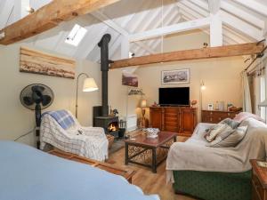 a living room with a couch and a fireplace at Walnut Cottage in Ross on Wye