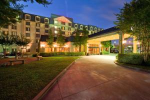 a large building with a courtyard at night at Hilton Garden Inn Houston Northwest in Houston