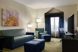 ein Wohnzimmer mit einem Sofa und Stühlen in einem Hotelzimmer in der Unterkunft Hilton Garden Inn Houston Northwest in Houston