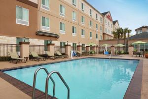 a swimming pool in front of a hotel at Hilton Garden Inn Houston/Clear Lake NASA in Webster