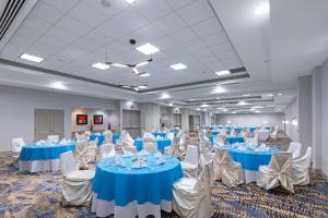 a banquet hall with blue tables and white chairs at Hilton Garden Inn Houston/Sugar Land in Sugar Land