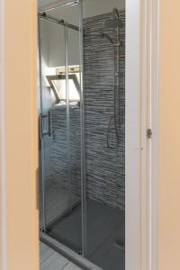 La salle de bains est pourvue d'une cabine de douche en verre. dans l'établissement Cortile Pace, à Catane