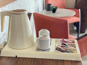 a table with a tea kettle and a tray with packets at Porto Del Sol Hotel in Paralia Katerinis
