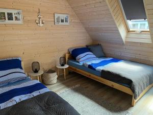 a bedroom with two beds in a attic at Nowe Domki Letniskowe in Pobierowo