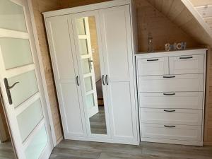 a bathroom with a mirror and a white cabinet at Nowe Domki Letniskowe in Pobierowo +24 photos