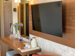 a large flat screen tv hanging on a wall at Porto Del Sol Hotel in Paralia Katerinis