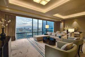 a living room with couches and a large window at DoubleTree by Hilton Heyuan in Heyuan
