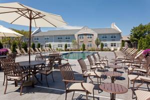 um grupo de mesas e cadeiras com guarda-sol em DoubleTree by Hilton Cape Cod - Hyannis em Hyannis