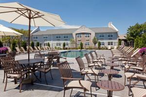 a group of tables and chairs with an umbrella at DoubleTree by Hilton Cape Cod - Hyannis in Hyannis