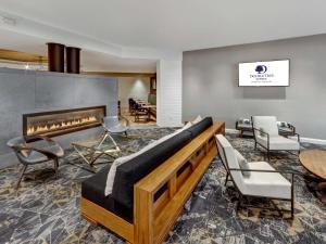 a living room with a couch and a fireplace at DoubleTree by Hilton Wichita Airport in Wichita