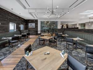 um restaurante com mesas e cadeiras e um bar em DoubleTree by Hilton Wichita Airport em Wichita