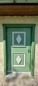 a green door on the side of a building at Ferienhaus am Haff in Hintersee