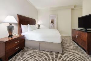 a hotel room with a bed and a flat screen tv at Hilton Houston Post Oak by the Galleria in Houston