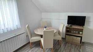 a small dining room with a table and a television at Apartment Andrea in Smoljanac