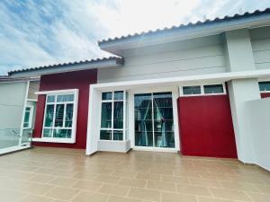 una casa roja y blanca con garaje rojo en Casa Forest Homestay, en Keluang