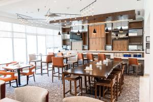 a restaurant with tables and chairs and a kitchen at Hilton Garden Inn Fairfax in Fairfax