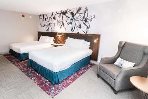 Hilton Garden Inn Fairfax في فيرفاكس: غرفة فندقية بسريرين وكرسي