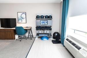 a room with a desk and a computer and a chair at Hilton Garden Inn Fairfax in Fairfax