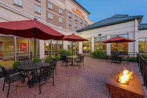 um pátio exterior com mesas e cadeiras e uma fogueira em Hilton Garden Inn Indianapolis South/Greenwood em Indianápolis