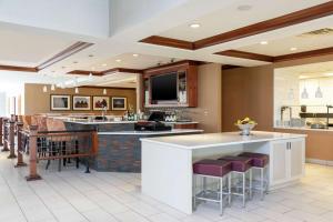 a large kitchen with a bar with stools at Hilton Garden Inn Indianapolis South/Greenwood in Indianapolis