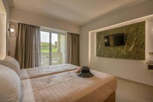 a hotel room with two beds and a window at Castro Beach Hotel in Maleme