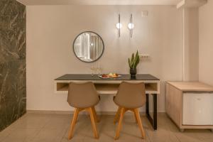 a dining room table with two chairs and a mirror at Castro Beach Hotel in Maleme