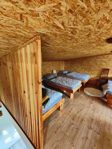 a room with three beds in a wooden cabin at Apartma Sveti Martin 