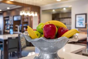 a bowl of fruit with bananas and apples at Hilton Garden Inn Islip/MacArthur Airport in Ronkonkoma