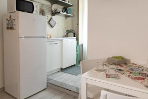 a kitchen with a white refrigerator and a table at Cortile Pace in Catania