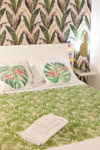 um quarto com uma cama com papel de parede verde e rosa em Cortile Pace em Catânia
