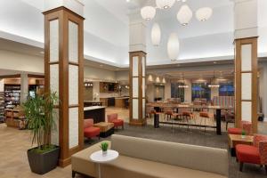 um átrio de uma biblioteca com mesas e cadeiras em Hilton Garden Inn Stony Brook em Stony Brook