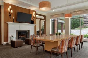 uma sala de jantar com uma mesa e uma lareira em Hilton Garden Inn Stony Brook em Stony Brook