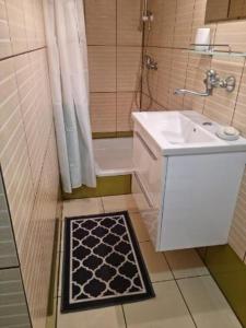 a bathroom with a sink and a shower and a bath tub at Apartament i domki wakacyjne w uroczym zakątku Ustki in Ustka