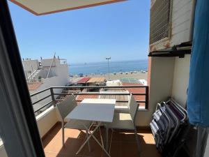 a balcony with a table and chairs and the ocean at Maravilloso apartamento en primera linea de playa con vistas al mar en Caleta de Vélez 2 C in Caleta De Velez