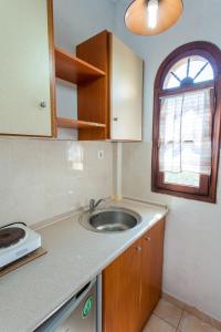 una pequeña cocina con fregadero y ventana en Villa Kalliopi en Gerakini