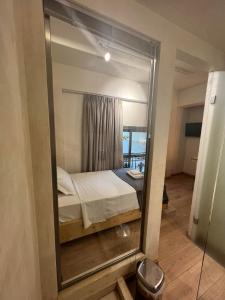 a mirror in a room with a bed in it at Panellinion Luxury Rooms in Kalamata