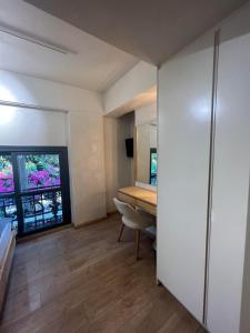 カラマタにあるPanellinion Luxury Roomsのデスクと窓が備わる小さな客室です。