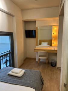a bedroom with a bed and a desk with a mirror at Panellinion Luxury Rooms in Kalamata
