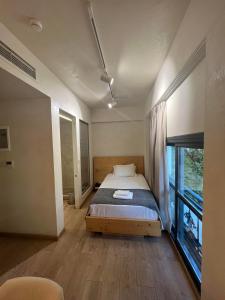 1 dormitorio con cama y ventana grande en Panellinion Luxury Rooms, en Kalamata